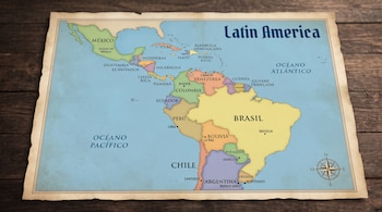 Mapa de América Latina sobre una mesa de madera con nombres de países, capitales, océanos Pacífico y Atlántico y rosa de los vientos.