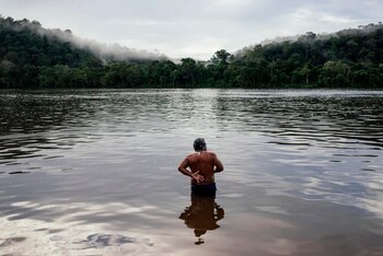 Un hombre indígena wayana bañándose