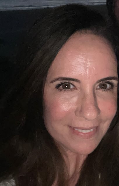 Noelle Balfour mira a la cámara y sonríe durante una toma de primer plano.