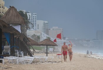 Turistas caminan por una playa