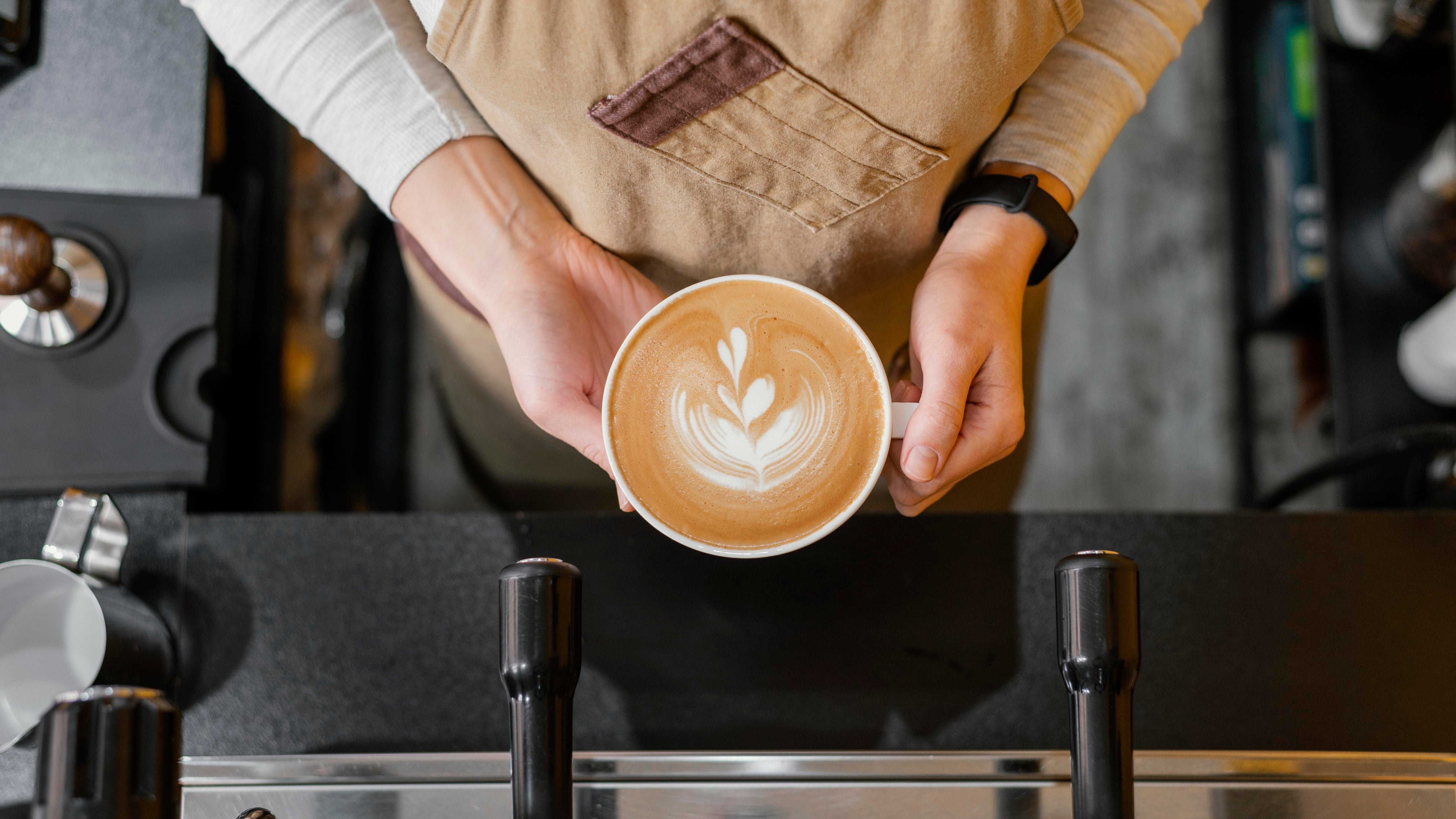 Un barista sirviendo una taza de café. (Freepik)