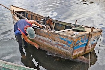 Fotografía del 29 de septiembre de 2026 de un pescador reparando su embarcación en la costa de Puerto Esperanza, en Pinar del Río (Cuba). EFE/ Ernesto Mastrascusa