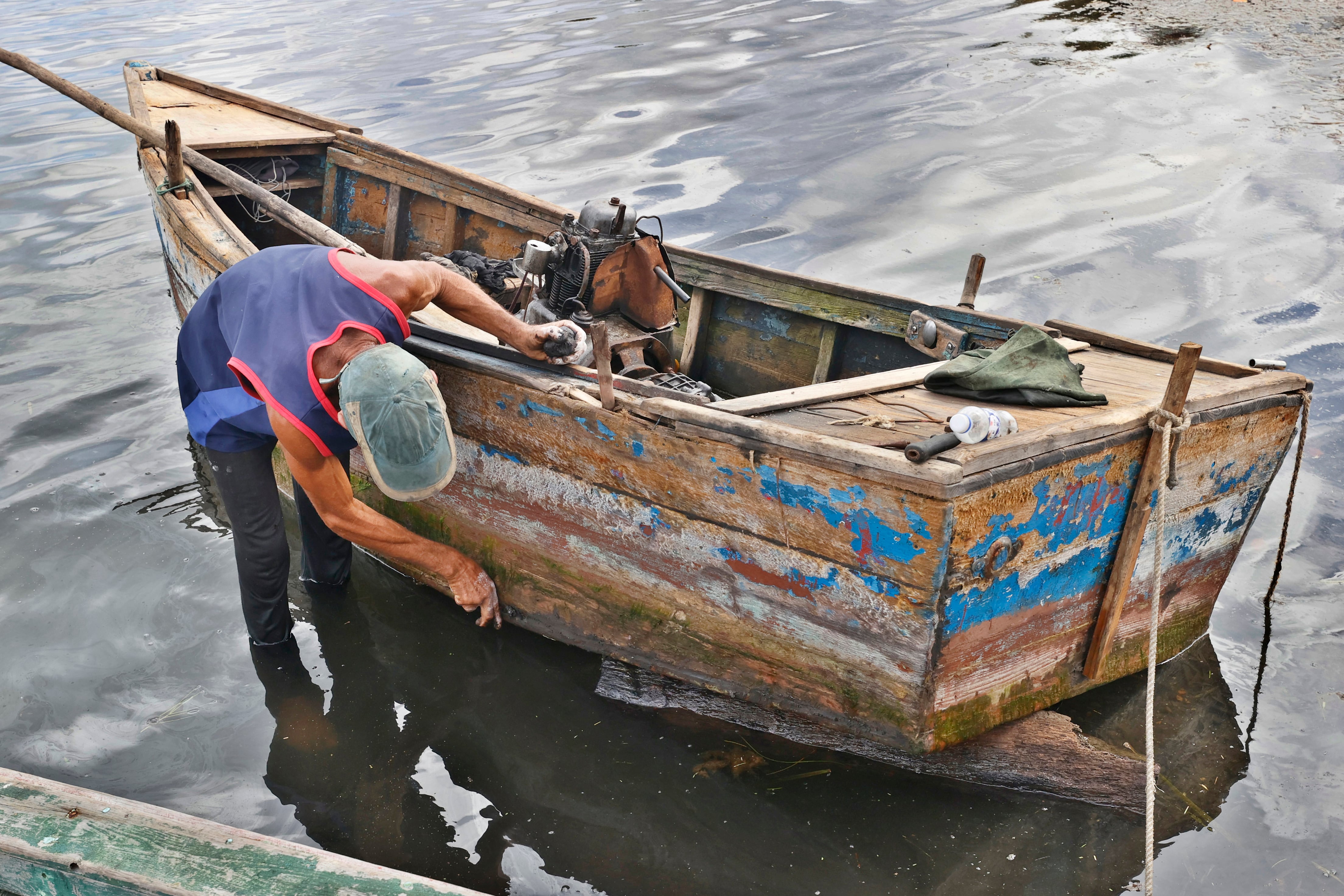 Fotografía del 29 de septiembre de 2026 de un pescador reparando su embarcación en la costa de Puerto Esperanza, en Pinar del Río (Cuba). EFE/ Ernesto Mastrascusa