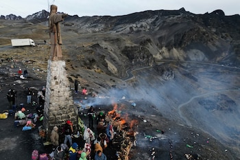 Personas se reúnen para quemar ofrendas a la Pachamama, o Madre Tierra, durante un antiguo ritual para pedir una buena cosecha en La Cumbre, una montaña sagrada a las afueras de La Paz, Bolivia, el sábado 1 de agosto de 2026. (Foto AP/Juan Karita)
