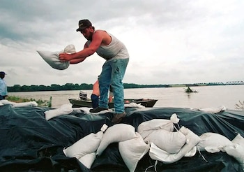Un hombre intenta frenar el avance del río Misisipi en el sur de Estados Unidos durante la Gran Inundación de 1993