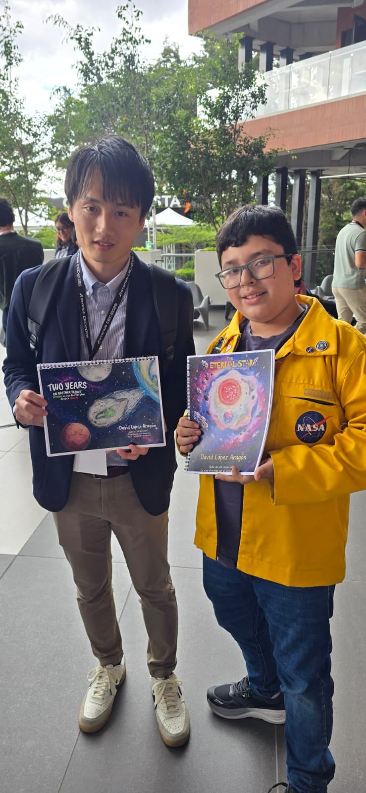 David López Aragón, de 11 años, presenta su ponencia sobre la exploración del universo junto a las banderas institucionales en un escenario. (Cortesía: Pamela López)