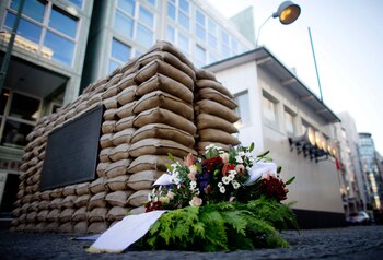 Una corona de flores junto a los sacos de arena del antiguo ""Checkpoint Charlie"", el puesto de control más famoso del muro que separó durante más de 30 años Berlín del Este y del Oeste. EFE/Kay Nietfeld/Archivo