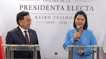 Mujer con micrófono y hombre de pie frente a podios. Fondo blanco con texto "Oficina de la Presidenta Electa Keiko Fujimori" y el escudo de Perú.