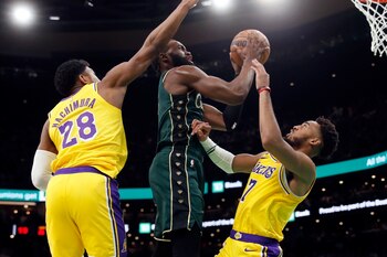 Jaylen Brown, de los Celtics de Boston, dispara entre Rui Hachimura y Troy Brown, de los Lakers de Los Ángeles, el sábado 8 de enero de 2023 (AP Foto/Michael Dwyer)