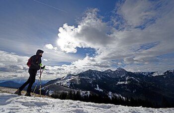 Eine Bergwandererin geht bei stürmischem