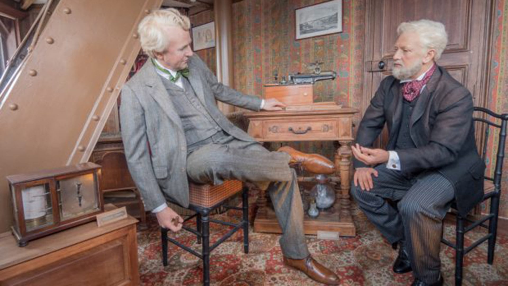 Figuras de cera de Eiffel y Edison a través de las ventanas del despacho