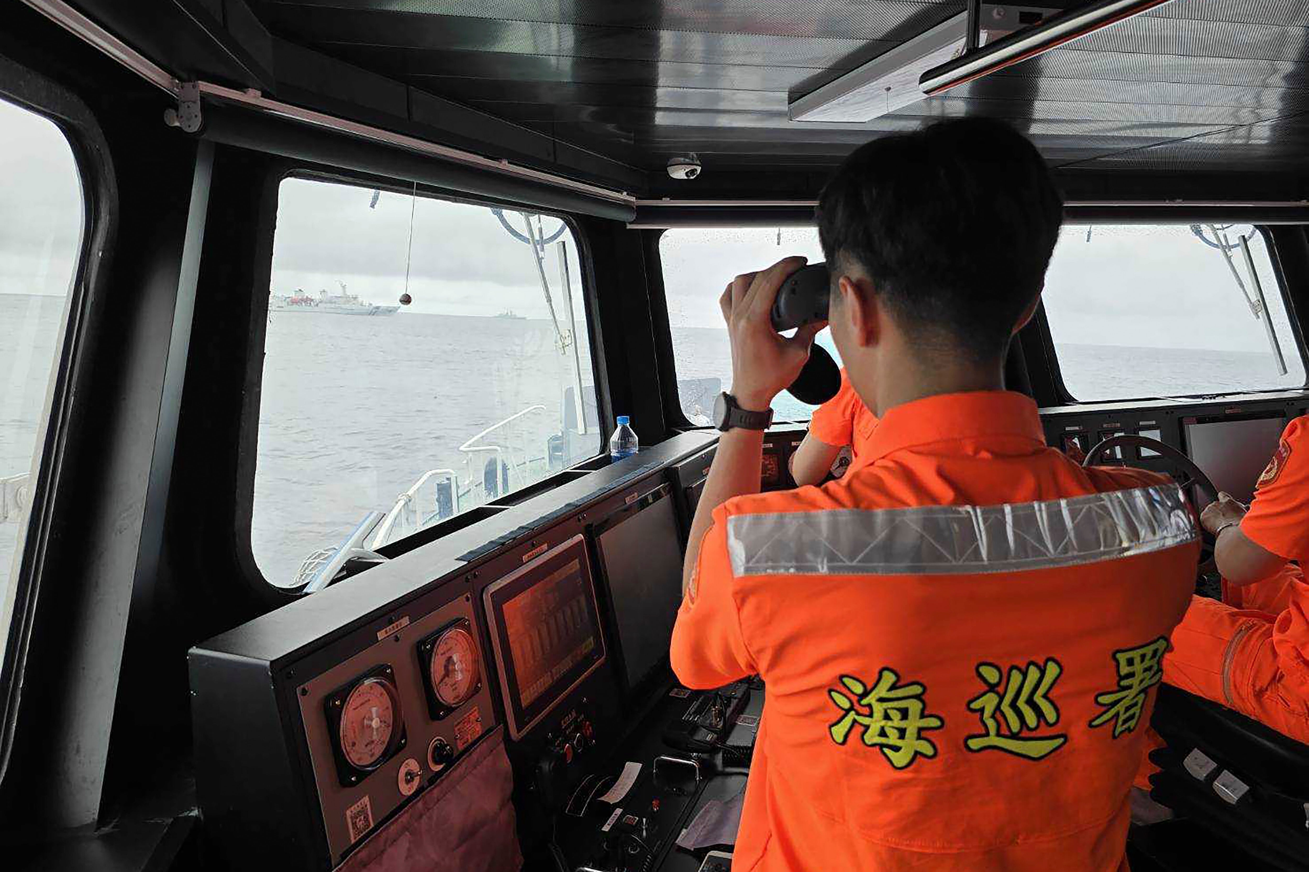 En esta imagen, distribuida por la Guardia Costera de Taiwán, un efectivo vigila un buque de la marina de China que opera cerca del islote de Pengjia (Guardia Costera de Taiwán vía AP, archivo)