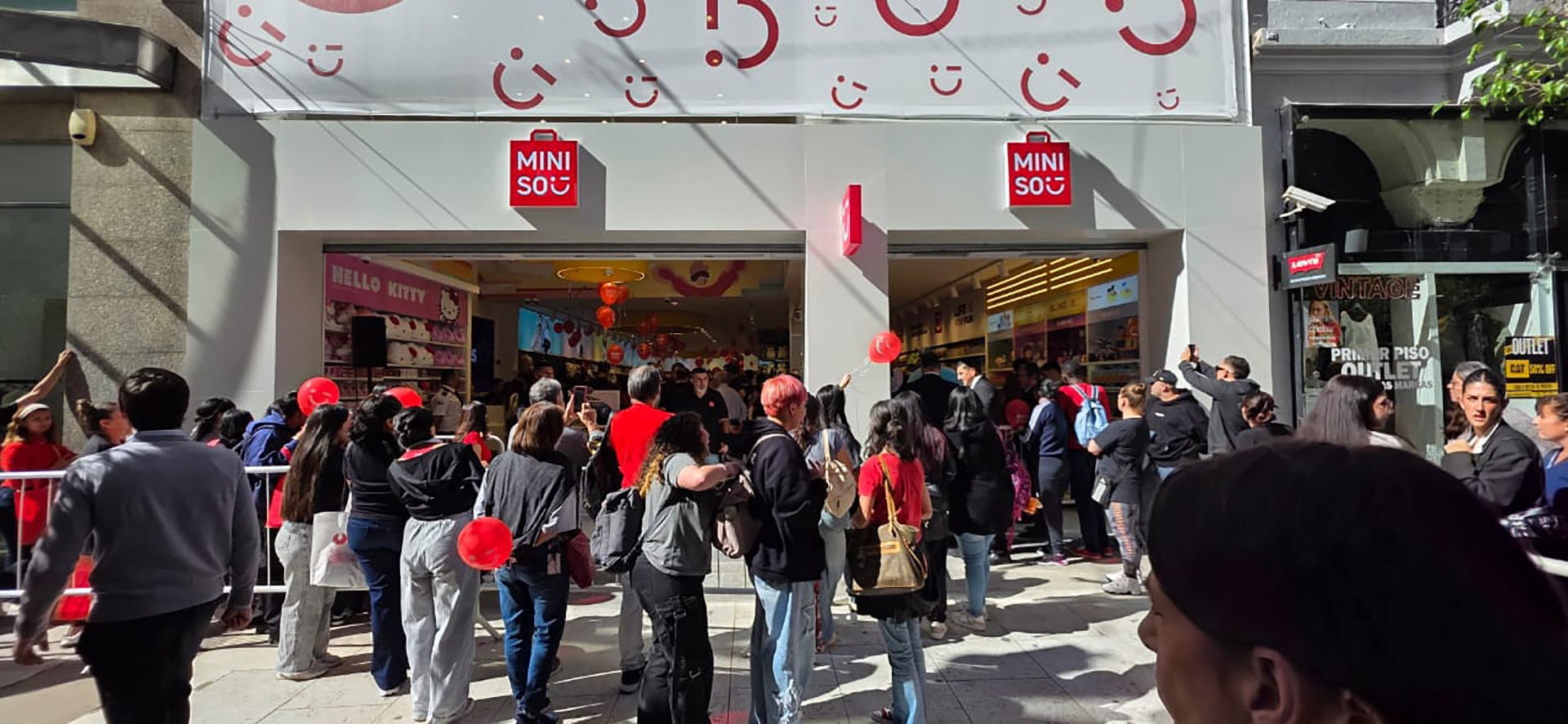 Entusiastas clientes hacen fila frente al nuevo local de Miniso, el primero en su tipo, ansiosos por descubrir los productos ofrecidos durante su gran apertura. (@SirChandlerBlog)