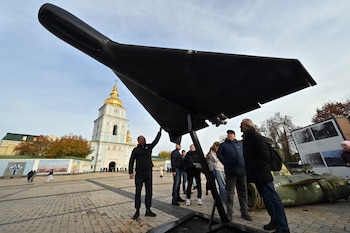 Personas observan un dron Shahed 136 (Geranium-2) de diseño iraní, perteneciente al ejército ruso, en una exposición al aire libre de equipo ruso destruido cerca de la Catedral de San Miguel de las Cúpulas Doradas en Kiev, el 2 de noviembre de 2025 (Sergei SUPINSKY/AFP)