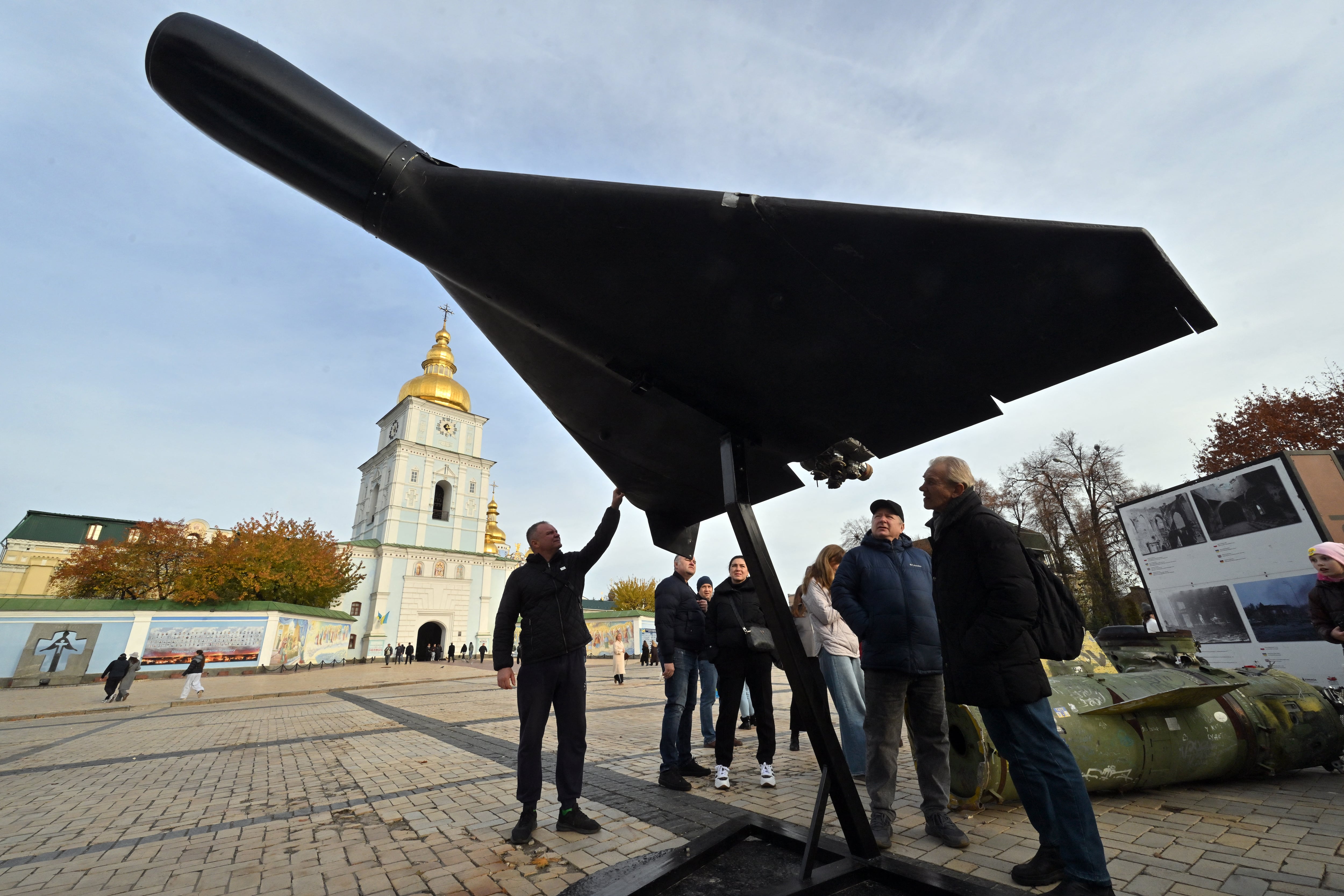 Personas observan un dron Shahed 136 (Geranium-2) de diseño iraní, perteneciente al ejército ruso, en una exposición al aire libre de equipo ruso destruido cerca de la Catedral de San Miguel de las Cúpulas Doradas en Kiev, el 2 de noviembre de 2025 (Sergei SUPINSKY/AFP)