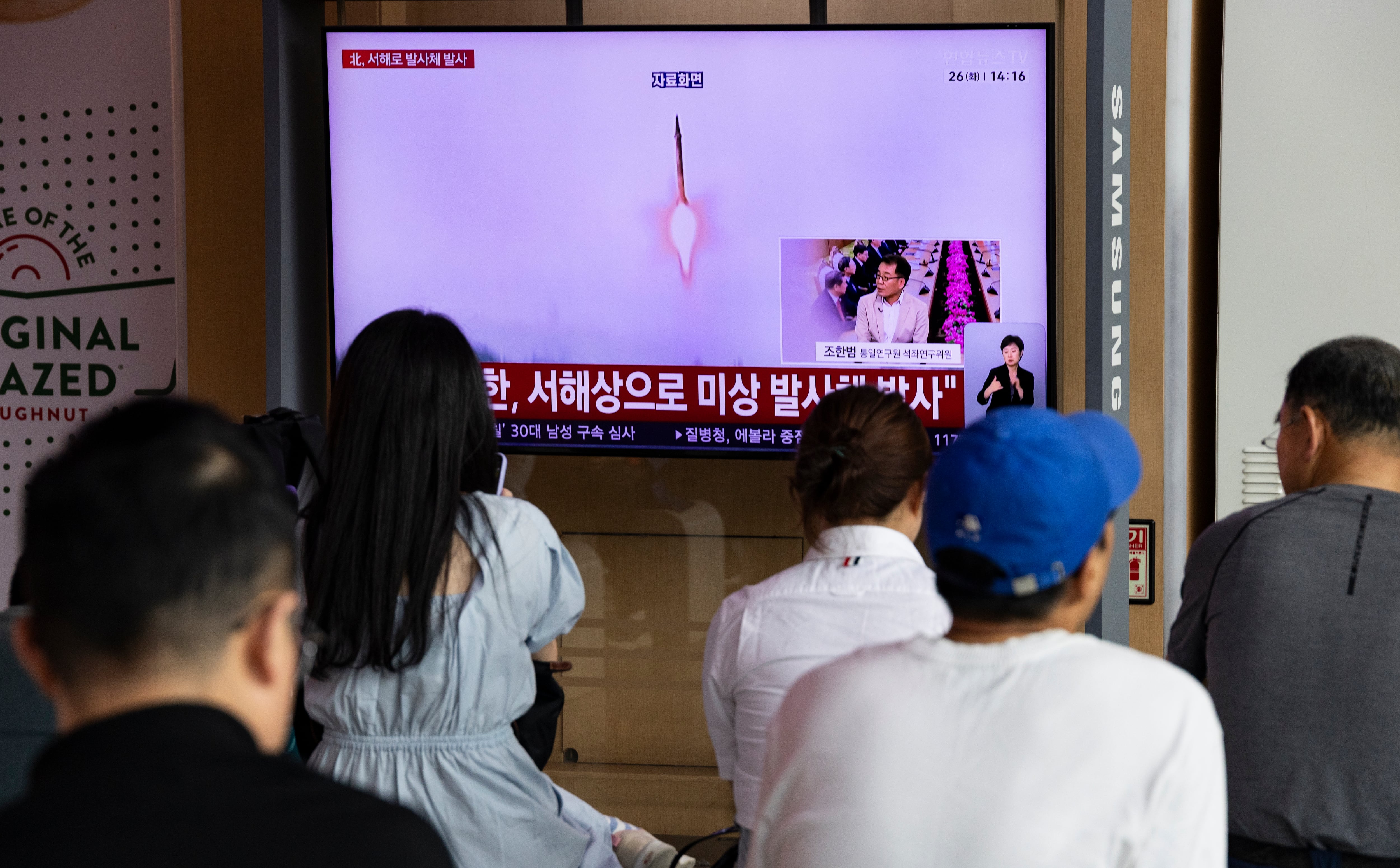 Transeúntes siguen las noticias en una pantalla de televisión en una estación de Seúl, horas después de que Corea del Norte lanzara un misil balístico de corto alcance y otros proyectiles hacia el mar, el 26 de mayo de 2026. (EFE)