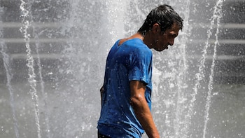 A man walks in the fountain in Washington Square Park as a heat wave hit the region in Manhattan, New York City