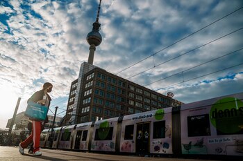 Una mujer con mascarilla camina