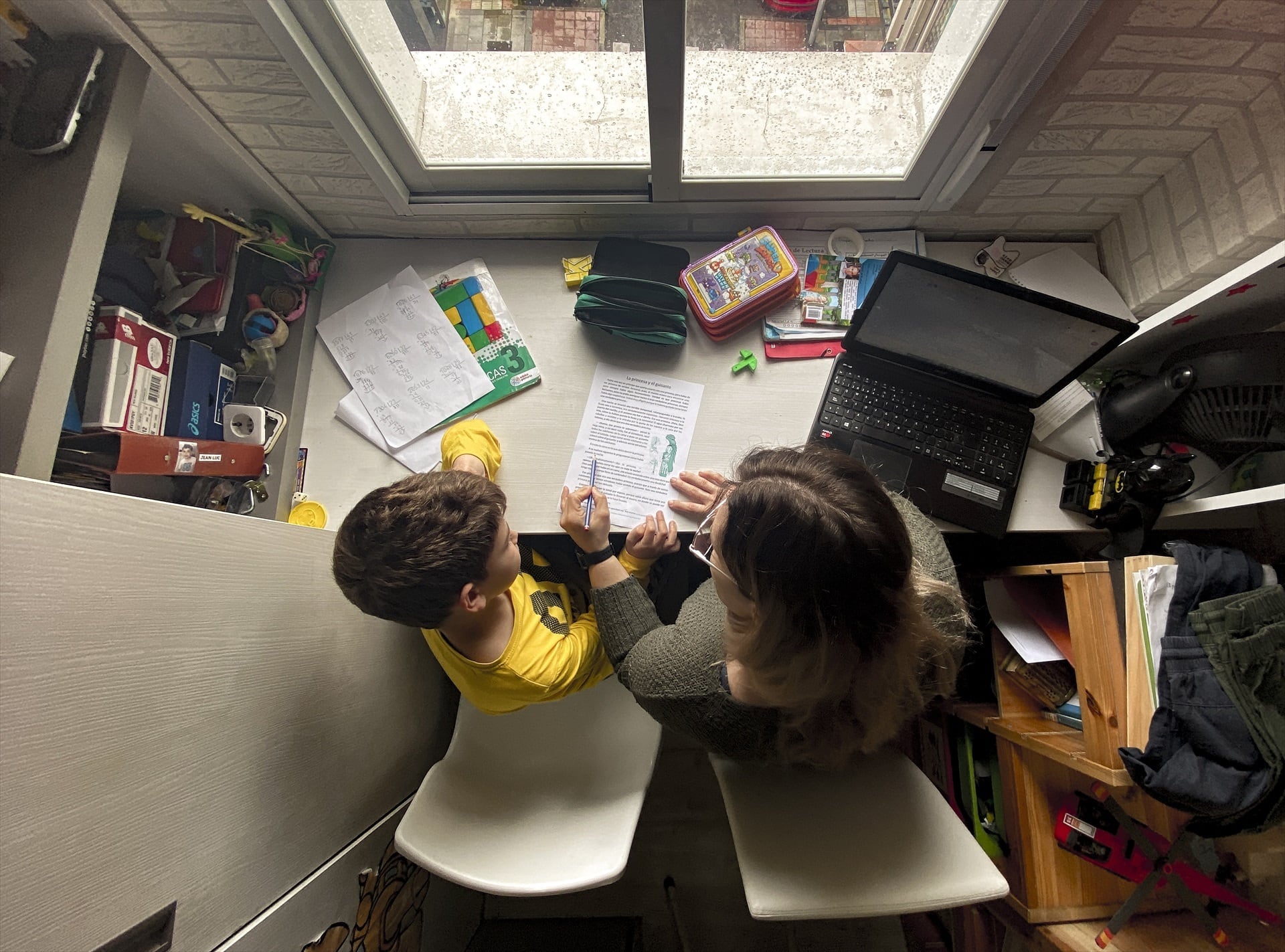 Un niño hace los deberes en casa con la ayuda de su madre. (Eduardo Parra / Europa Press)
