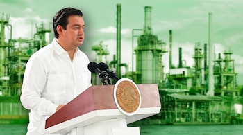 Un funcionario mexicano en camisa blanca pronuncia un discurso desde un podio adornado con el escudo nacional, con una planta industrial verde y blanca difuminada de fondo. (Imagen Ilustrativa Infobae)
