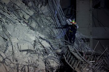 A rescue personnel searches for casualties at the site of a building that collapsed after a strong earthquake struck central Myanmar on Friday, earthquake monitoring services said, which affected Bangkok as well with people pouring out of buildings in the Thai capital in panic after the tremors, in Bangkok, Thailand, March 28, 2025. REUTERS/Athit Perawongmetha TPX IMAGES OF THE DAY
