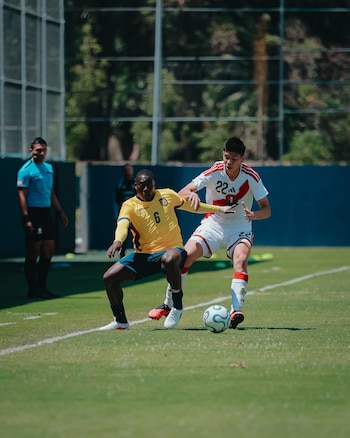 Matías Bordón, futbolista de la Universidad Católica de Chile, disputa un balón con su rival ecuatoriano.