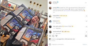 Phillip Chu Joy sonriente, sosteniendo tres cajas de PlayStation 5 en un interior con estantes llenos de objetos de colección y trofeos dorados al fondo