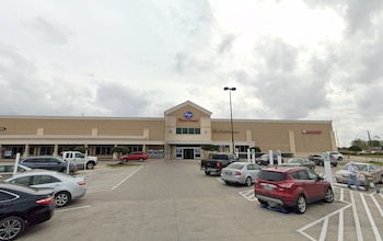 Fachada de un supermercado Kroger con automóviles en el estacionamiento y un cielo nublado al fondo