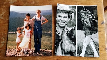 Dos fotos impresas sobre una mesa de madera: una foto familiar en color y dos imágenes en blanco y negro de un hombre con sombrero.