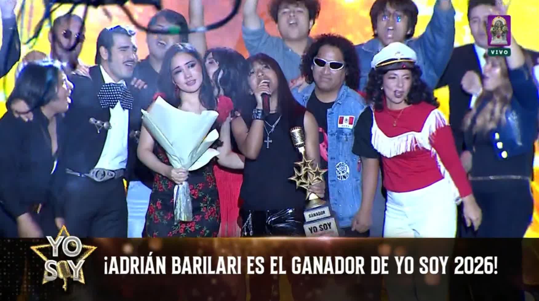 El imitador Mr. Nik sostiene el trofeo y canta en el escenario junto a otros participantes tras consagrarse ganador del programa de televisión Yo Soy.