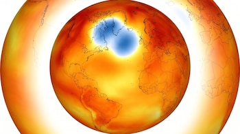 Mapa de la Tierra en un globo con colores que representan temperaturas. Predominan tonos cálidos (naranja, amarillo) y una zona azul frío sobre Groenlandia.