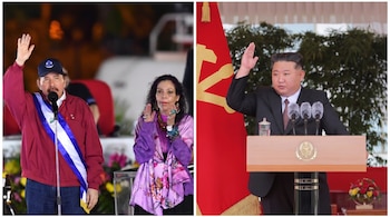 Daniel Ortega con gorra azul y banda presidencial, Rosario Murillo de morado, y Kim Jong Un de traje oscuro ante un podio con micrófono y una bandera roja.