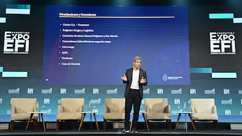 Luis "Toto" Caputo, de pie en un escenario, gesticula mientras habla frente a una pantalla gigante que muestra "Privatizaciones y Concesiones" y el logo de ExpoEFI