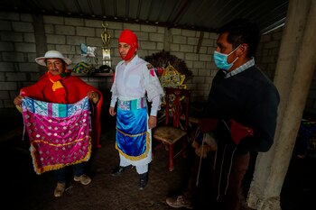 Danilo Congacha Saquinga (i) muestra algunos de los trajes típicos usados por los danzantes de San Andrés, este miércoles 24 de junio de 2021, en Pillaro (Ecuador). EFE/ José Jácome