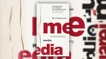 Portada blanca y roja del libro Comprender los medios de comunicación de Marshall McLuhan sobre un fondo gráfico desenfocado.