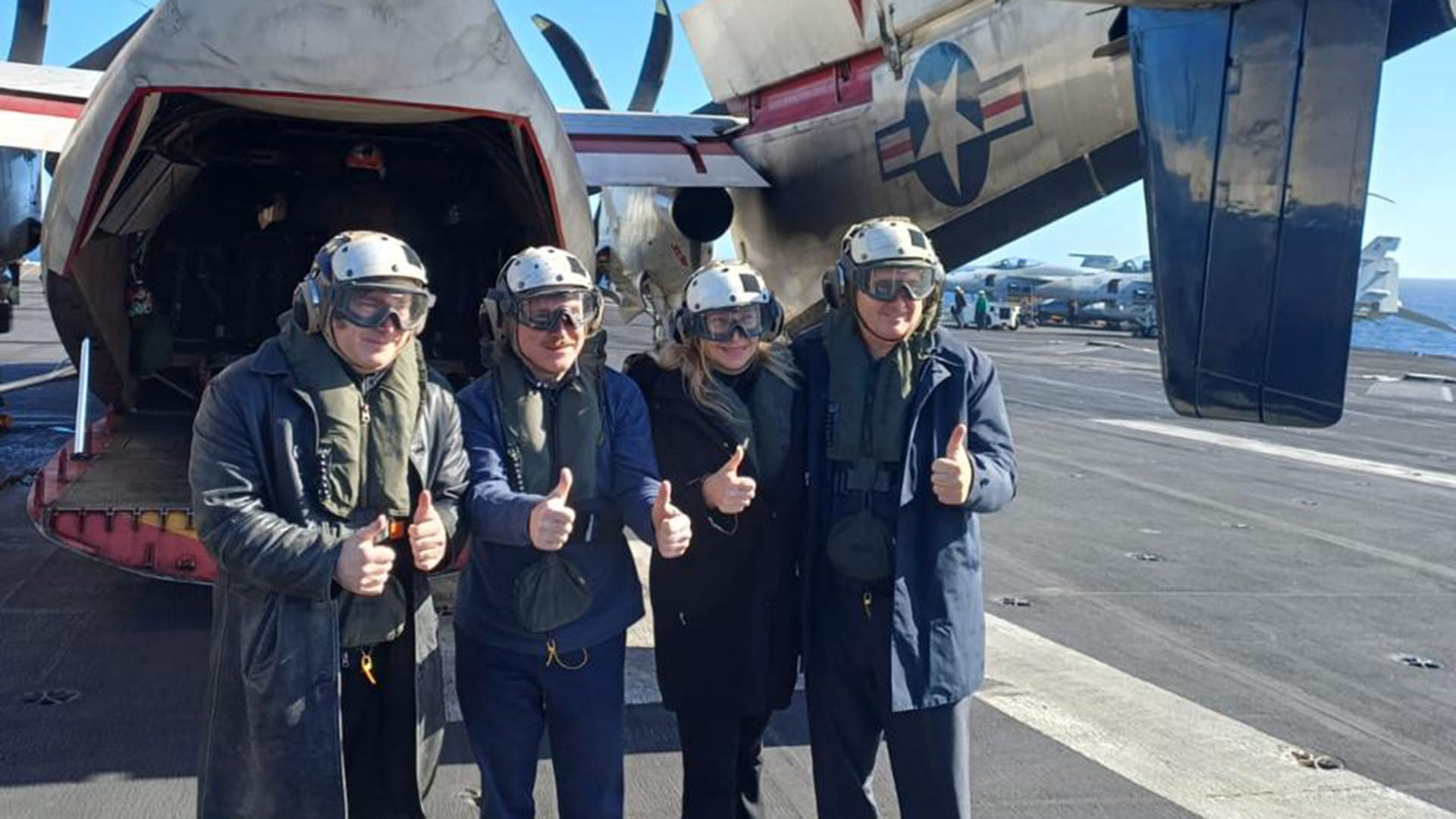 El presidente Javier Milei, junto a la embajadora y otros funcionarios argentinos, posa con equipo de vuelo y pulgar arriba a bordo del portaaviones USS Nimitz durante ejercicios navales conjuntos con Estados Unidos