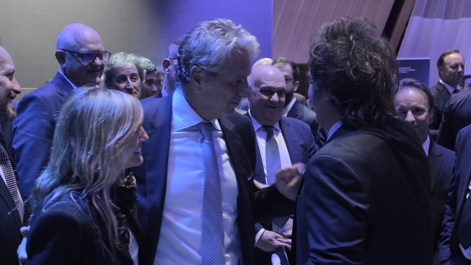 Milei en otro pasaje del encuentro conversando con Juan Pazos, ex titular de ARCA, e integrantes de su delegación y asistentes en París.
