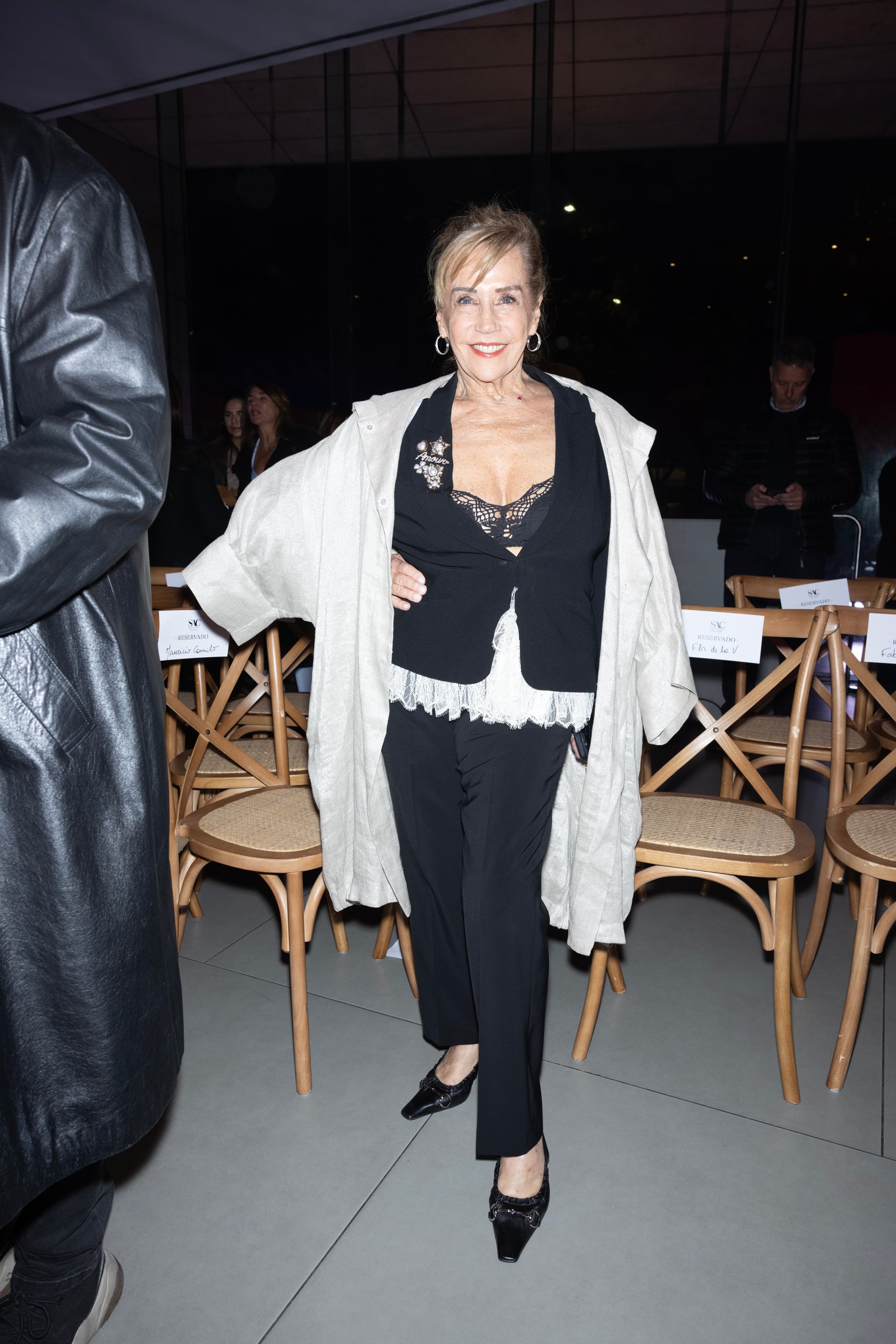 Marcela Tinayre posa de pie junto a las sillas reservadas en un evento de moda. (SAC - MALBA)
