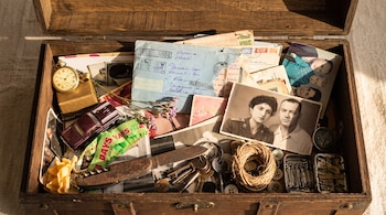 Caja de madera con fotografías, cartas escritas a mano, llaves, un reloj de bolsillo, una navaja y un rollo de cordel.