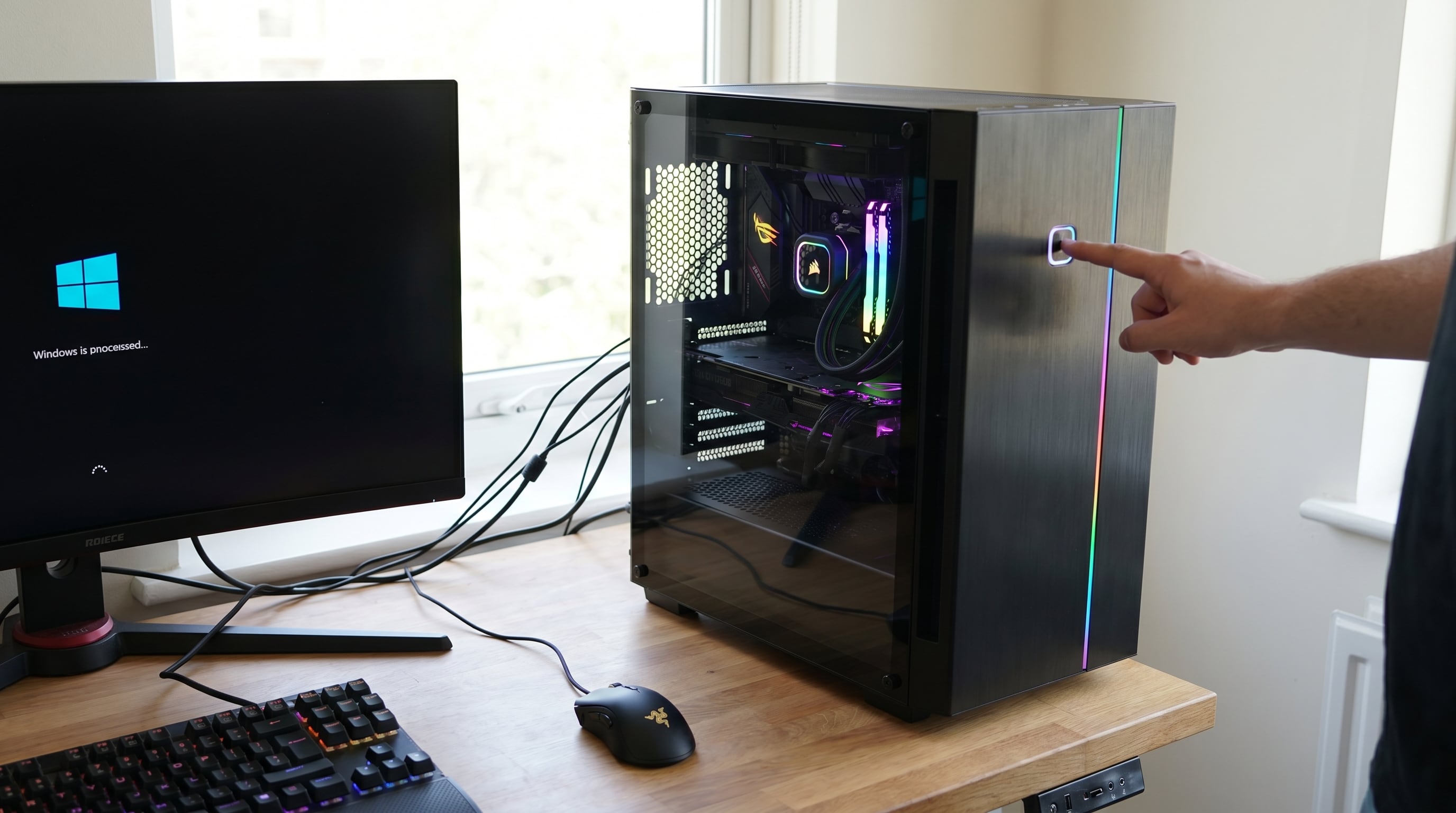 Un usuario enciende una moderna computadora de alto rendimiento con componentes internos iluminados por LED, mientras el sistema operativo Windows comienza a cargar en la pantalla. (Imagen Ilustrativa Infobae)