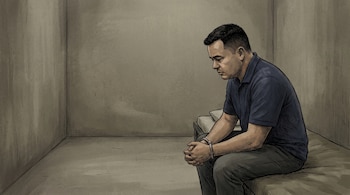 Ilustración de un hombre sentado con esposas en una cama dentro de una celda. Viste camisa azul, pantalón oscuro y mira hacia abajo.