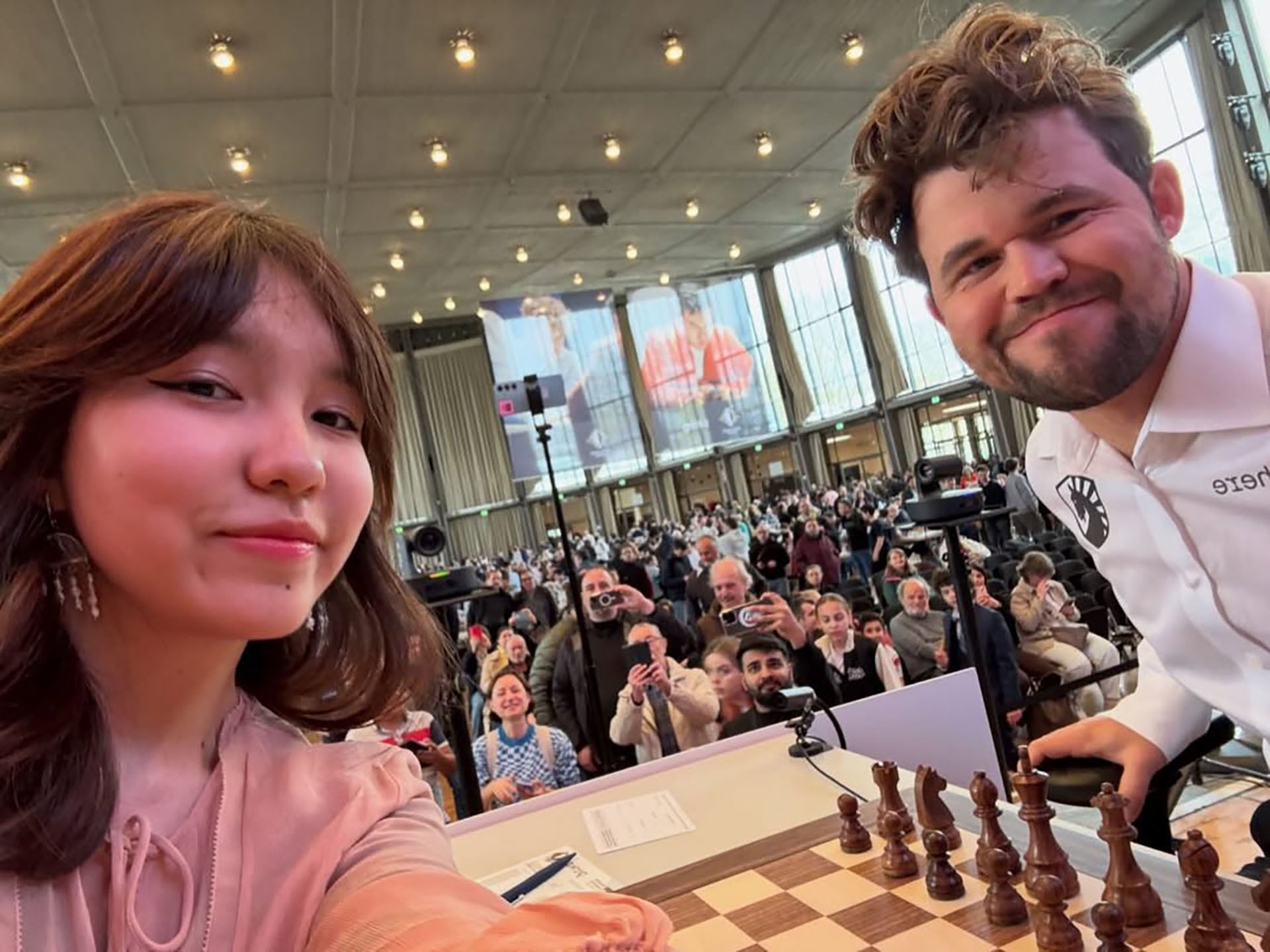 La ajedrecista Alua Nurman y Magnus Carlsen posan para una selfie antes de una partida, en la que Carlsen la acusó de usar un teléfono.