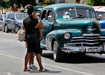 LA HABANA (CUBA), 24/08/2026.- Fotografía del 20 de agosto de 2026 que muestra a una mujer cruzando una calle con una niña en sus brazos en La Habana (Cuba). El embarazo adolescente en Cuba es considerado un "serio problema social y de salud" por las autoridades de la isla, donde en torno al 18-19 % de los nacimientos son de madres de entre 15 y 19 años. EFE/ Ernesto Mastrascusa