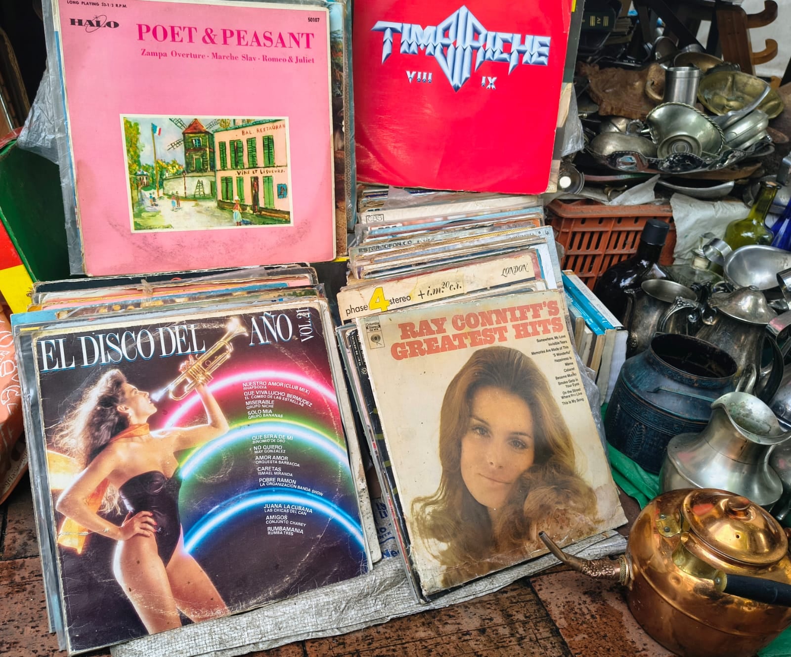 Son algunas de las portadas que se ven en la foto, apiladas entre acetatos que cruzan décadas: Ray Conniff’s Greatest Hits (1969), Poet & Peasant de Halo Records (c. 1957), El Disco del Año (Vol. 14) (1982) y el doble de Timbiriche (1988), listas para volver a sonar en vitrola - crédito Santiago Neira