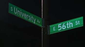 Dos letreros verdes sobre un poste nocturno indican la intersección de las calles South University Avenue y East 56th Street