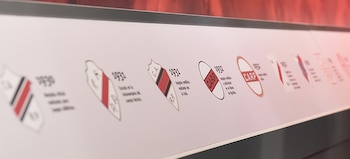 Una exhibición muestra escudos de River Plate blancos con franjas rojas y negras, fechas y texto explicativo. El logo de River Plate está en la esquina inferior derecha