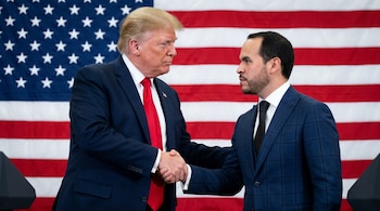 Donald Trump y Abelardo de la Espriella, ambos con traje y corbata, se dan un apretón de manos frente a una bandera de Estados Unidos.