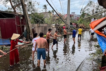 Varias personas retiran árboles caídos tras el impacto del tifón Yagi, en Hai Phong, Vietnam (REUTERS/Minh Nguyen)