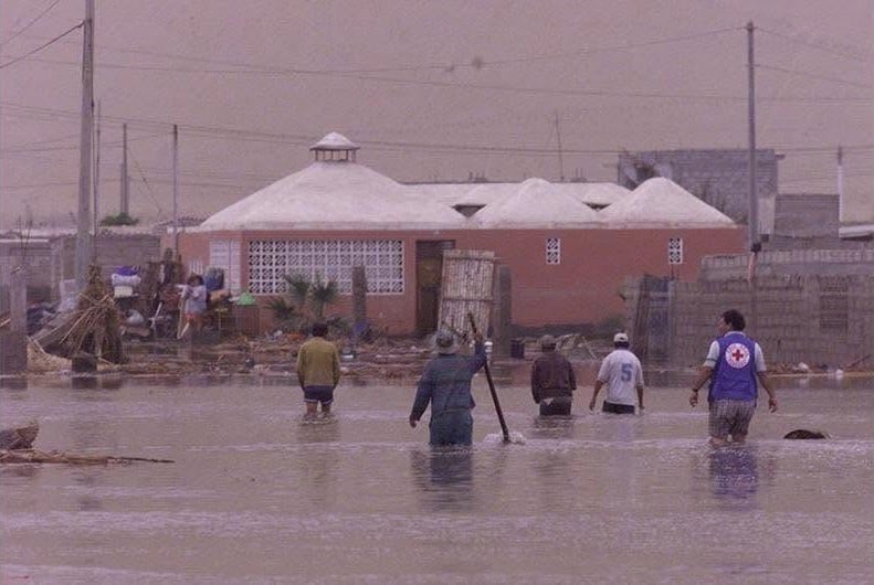 Pobladores y personal de auxilio recorren las calles inundadas de Camaná luego del tsunami provocado por el terremoto de magnitud 8,4 en junio de 2001.