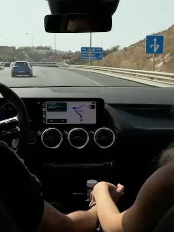 Una de las imágenes más íntimas del carrusel: la pareja tomada de la mano durante un recorrido en auto por España